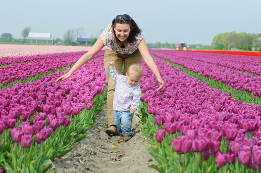 Mother with son in the purple tulips field