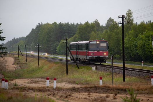 Light railbus passing the rainy forest
