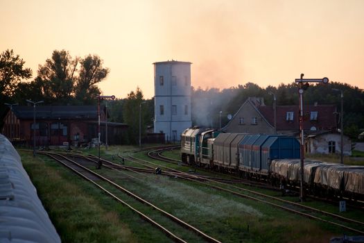 Freight train hauled by the diesel locomotive passing the station
