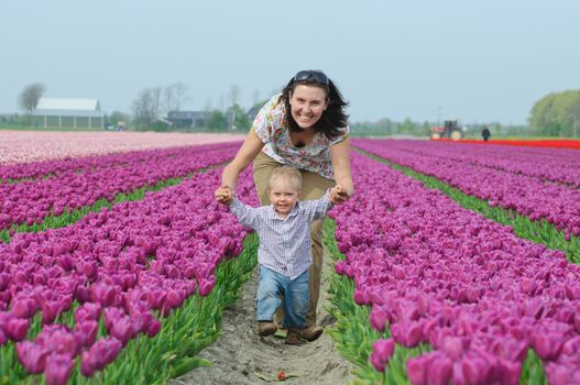 Mother with son in the purple tulips field