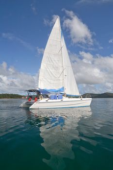 Luxury white catamaran boat in the bay with reflexion in the sea