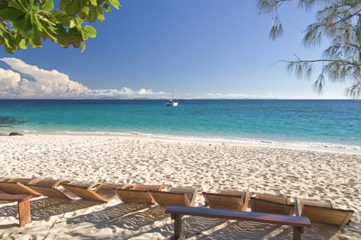 Deck chair, beach and sailboat