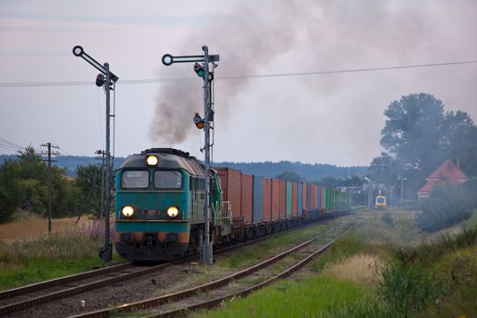 Freight train hauled by the diesel locomotives starting from the station
