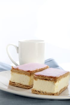 Tompouce, a common pastry  in the Netherlands and Belgium made  with puff pastry , filled with sweet yellow pastry cream and topped with pink icing.