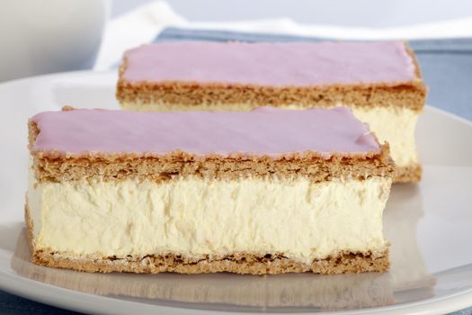 Tompouce, a common pastry  in the Netherlands and Belgium made  with puff pastry , filled with sweet yellow pastry cream and topped with pink icing.