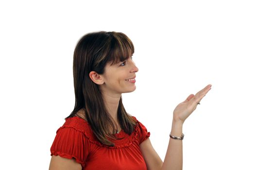 A lovely young brunette hostess points to frame right with a captivating smile.  She appears to be looking at the item to which she's pointing.