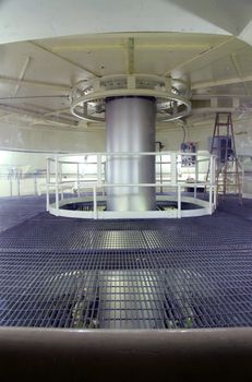 A long shaft from a generator below rotating at a set speed creating electricity, a clean energy.