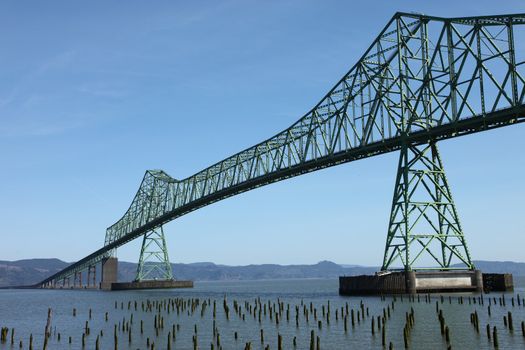The historic 4.2 mile long, 200 feet high, bridge over the mouth of the Columbia River in the Pacific Northwest view from the Astoria Oregon side. Clear sunny blue skies. 2000 cargo ships a year pass underneath it.
