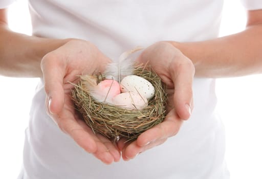 Eggs in a nest cupped in heart shaped hands. 