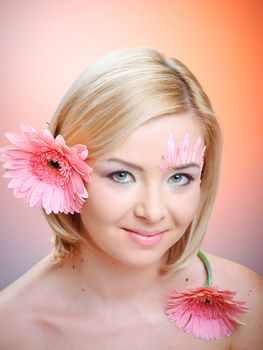 Close-up of woman green eye. Pink flower on background.