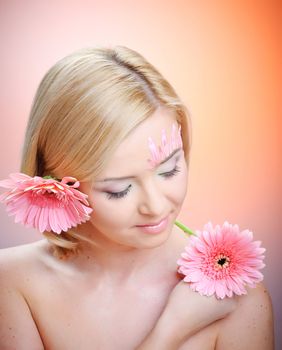 Close-up of woman green eye. Pink flower on background.