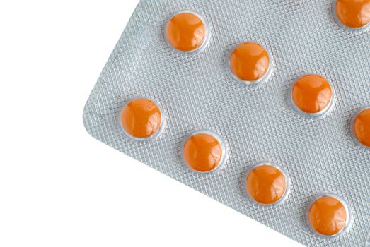 Close-up of a pack of orange pills on white background.