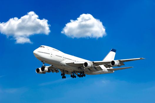 Jumbo jet and two clouds on a blue sky