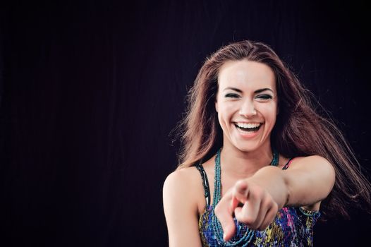 Joyful woman with long brown hairs. Isolated on black