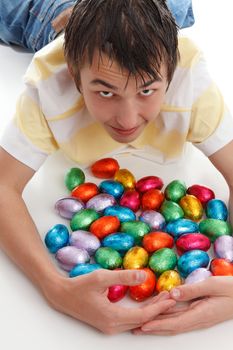 A boy gathers together plenty of easter eggs.