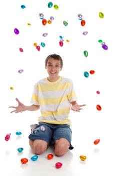 Excited happy boy with many easter eggs all around him.  White background.