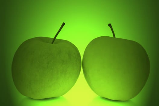 Two fresh apples in an abstract green light effect