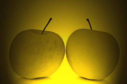 Two fresh apples surrounded by golden light effect filter