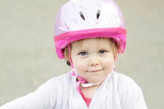 Cute little girl with bicycle helmet outdoors