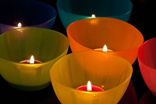 colored plastic cups with candles, close-up