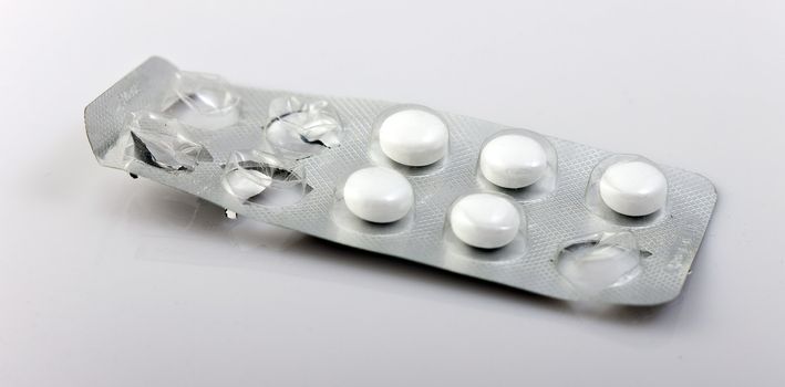 used packaging of pills and reflecting, gray background