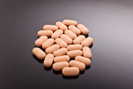 A handful of rose pills on a gray background