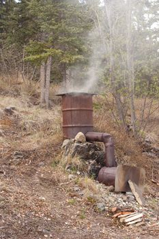 Home-made smoker for preservation of fish and meat by fumigation in action.