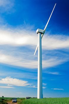 Wind turbine and small car on agricultural land