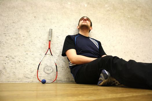 A handsome man playing squash in the hall