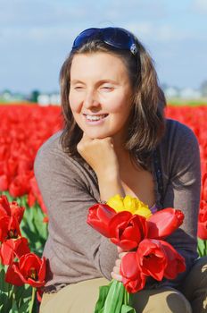 Happy women with red tulip in tulips field.