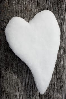 Valentine�s Day Heart formed from snow on weathered timber surface.