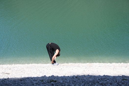 Young man stretching on beach