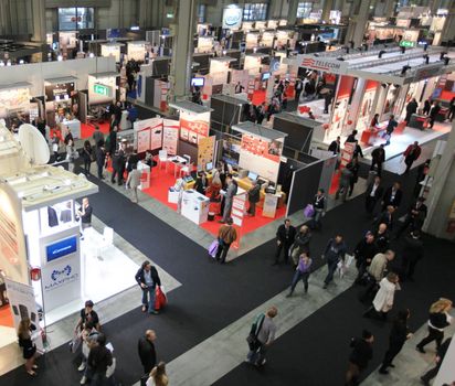 Panoramic view of people visiting technologies stands during SMAU, international fair of business intelligence and information technology in Milan, Italy.