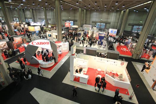 Panoramic view of people visiting technologies stands during SMAU, international fair of business intelligence and information technology in Milan, Italy.