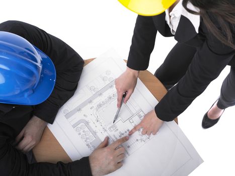 Two architects with hard hats and plan on meeting in office