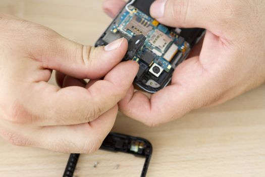 Clean hands are repairing electronics.