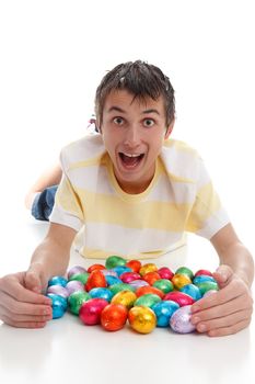 Excited boy in casual clothing with lots of easter eggs.  White background.