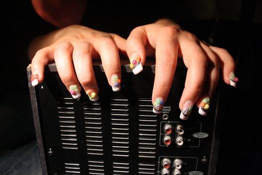 Hands with beautiful nails on a jukebox