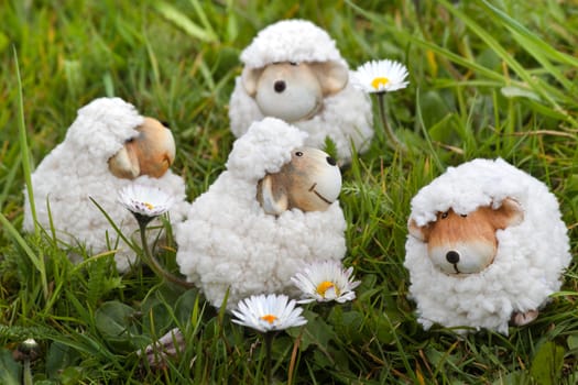 Easter- or spring decoration - funny little sheep in grass with daisies