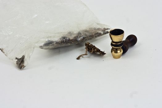 Marijuana and pipe on a white background