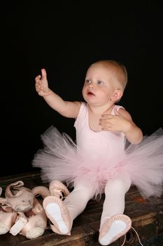 Cute baby ballerina wearing a pink leotard and tutu
