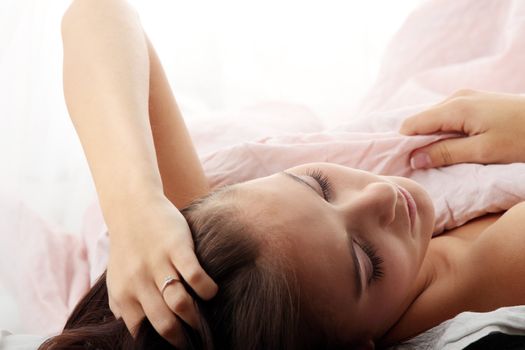 Sensual young woman laying in pink bed. Sleeping