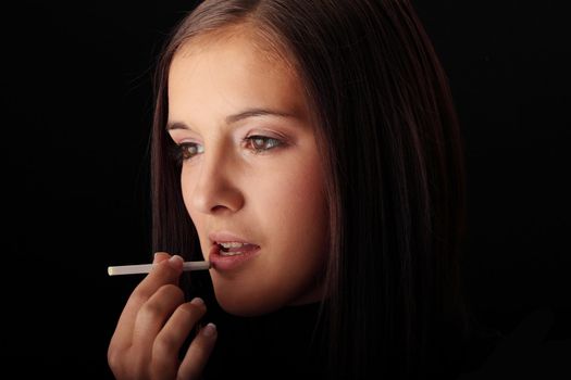 Young woman using cigarette as lipstick - anty smoke concept