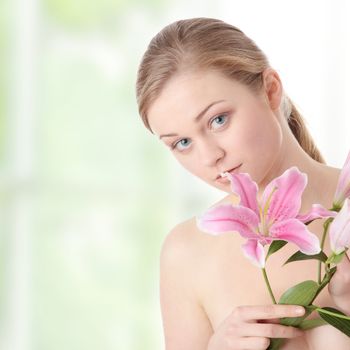Portrait of young beautiful blond woman with lily flower