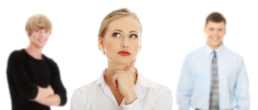 Thoughtful business woman looking right (making a choice) , isolated over a white background. Two young man in background