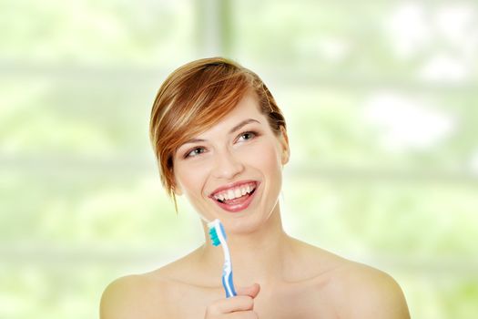 Happy teen girl singing to tooth brush