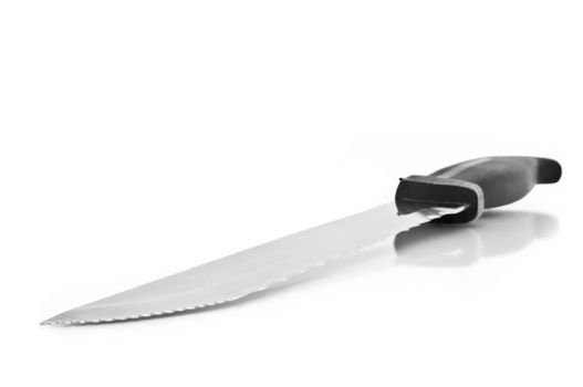Close and low level angle capturing a stainless steel kitchen knife arranged over white