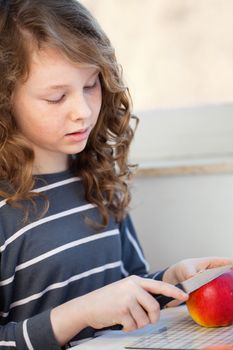 Cute teen girl cutting in the kitchen and cutting an apple with a knife