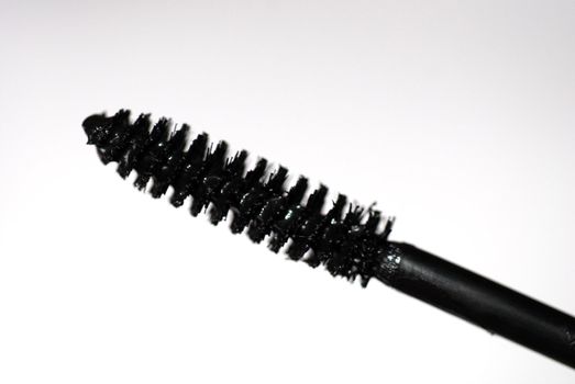 Extreme close-up of a mascara wand against a white background