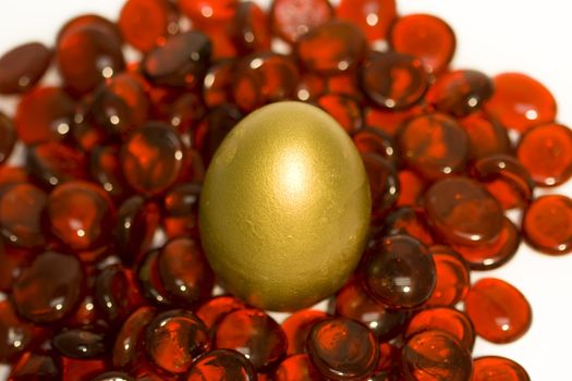 Golden egg set on red glass stone background